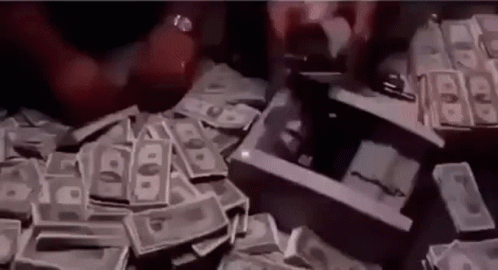 A Pile Of Money Is Sitting On Top Of A Table Next To A Gun . GIF