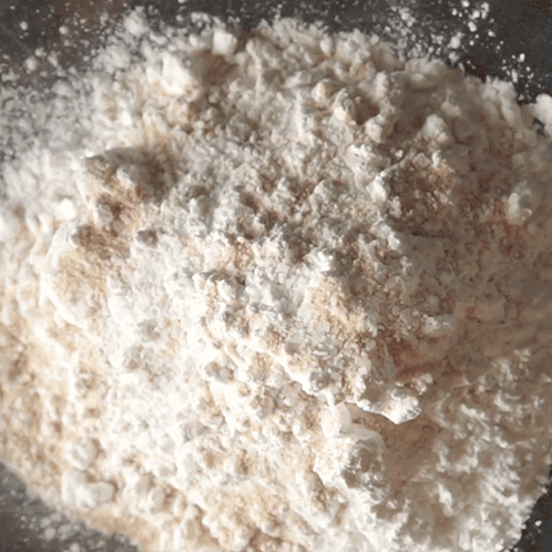 A Pile Of White Powder Is Sitting On A Gray Surface GIF
