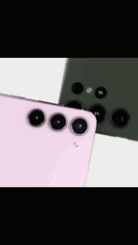 A Pink And A Green Cell Phone Are Sitting On Top Of Each Other On A Table . GIF