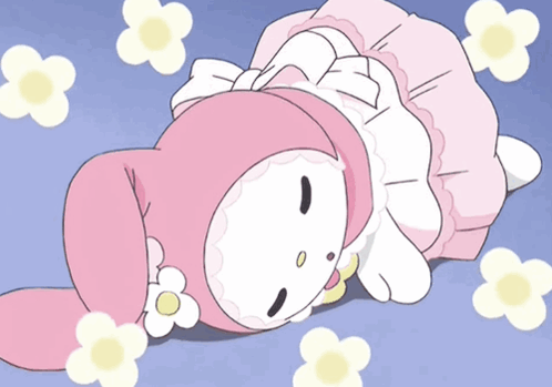 A Pink And White Cartoon Character Is Laying On The Ground With Flowers Around Her GIF