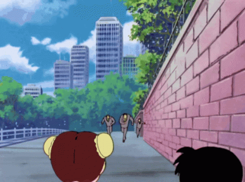 A Pink Brick Wall Is Surrounded By Trees And Buildings In The Background GIF