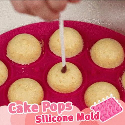 A Pink Cake Pops Silicone Mold With A Person Sticking A Stick In It GIF