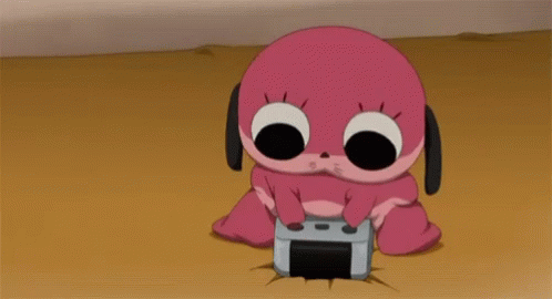 A Pink Cartoon Character Is Sitting On The Ground Holding A Video Game Controller GIF
