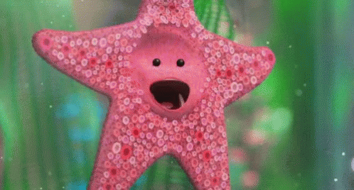 A Pink Starfish With A Face On It Is Swimming In A Tank . GIF