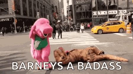A Pink Stuffed Animal Is Standing Next To A Person In A Dinosaur Costume On A Street . GIF