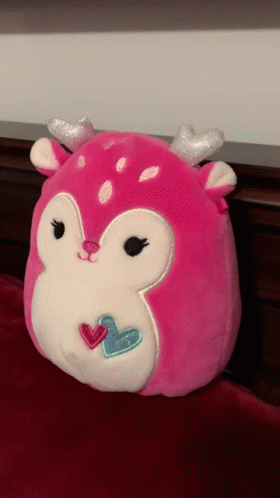 A Pink Stuffed Animal With Silver Antlers And Hearts On Its Face GIF