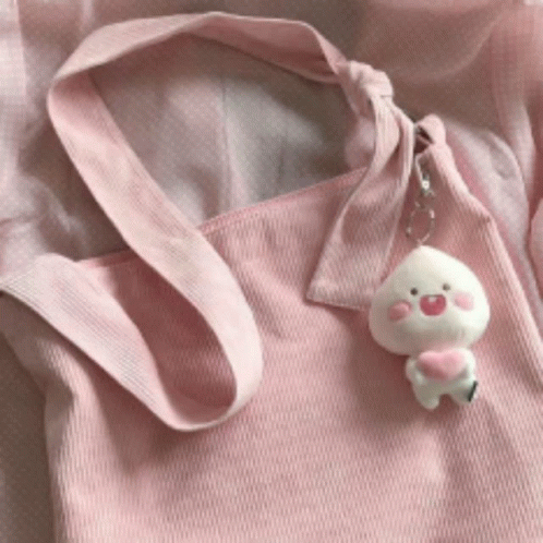 A Pink Tote Bag With A Peach Keychain Attached GIF