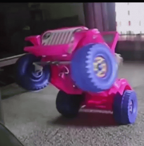 A Pink Toy Jeep With Blue Wheels And Tires GIF