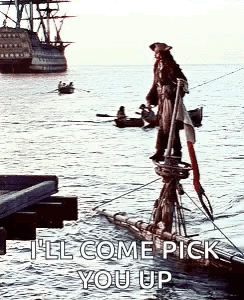 a pirate is standing on the side of a boat in the water with a ship in the background .