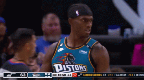 A Pistons Basketball Player Stands In Front Of The Scoreboard GIF