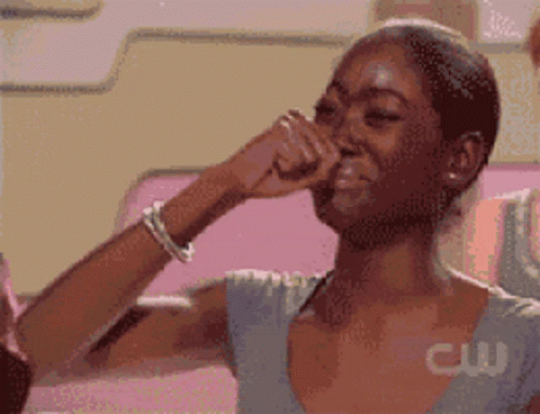 A Pixelated Image Of A Woman Covering Her Nose With Her Hand With A Cw Logo Behind Her GIF
