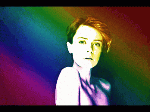 A Pixelated Image Of A Woman With A Rainbow Colored Background GIF