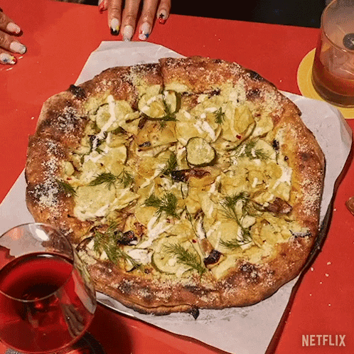 A Pizza With A Glass Of Wine Next To It And A Netflix Logo GIF