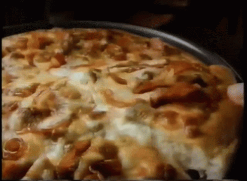 A Pizza With A Lot Of Toppings Is Being Eaten GIF