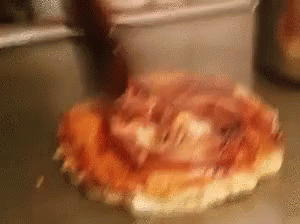 a pizza with ham and cheese is sitting on a counter .