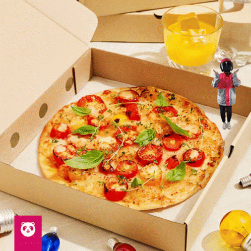 A Pizza With Tomatoes And Basil Is In A Box Next To A Glass Of Orange Juice GIF