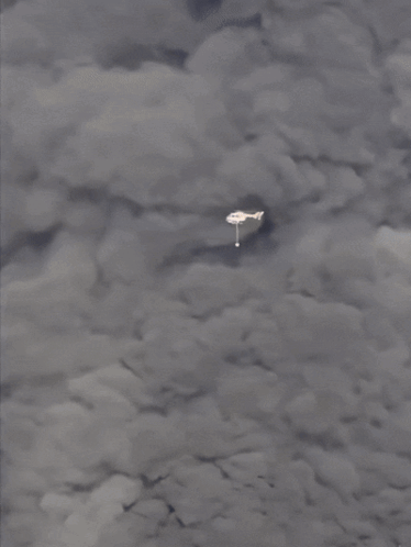 A Plane Is Flying Through A Cloudy Sky With A White Object In The Foreground GIF