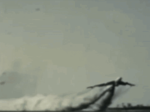 A Plane Is Flying Through The Air With Smoke Trails Behind It GIF