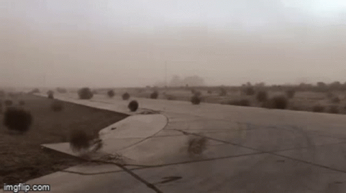 A Plane Is Taking Off From An Airport Runway During A Sandstorm . GIF