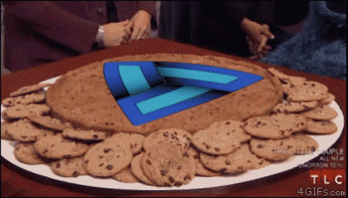 A Plate Of Chocolate Chip Cookies With A Blue Triangle In The Middle GIF