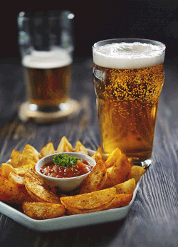 A Plate Of Fries And A Glass Of Beer On A Wooden Table GIF