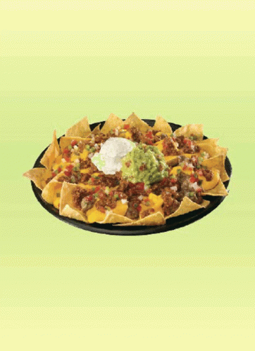 A Plate Of Nachos With Guacamole And Sour Cream On A Green Background GIF