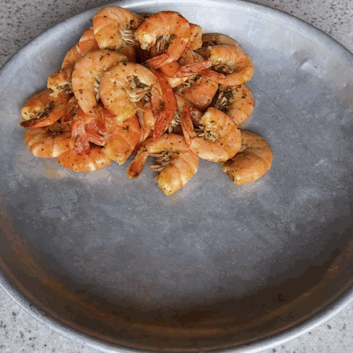 A Plate Of Shrimp Is Sitting On A Counter GIF