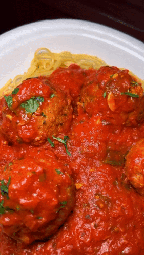 A Plate Of Spaghetti And Meatballs With Sauce On It GIF
