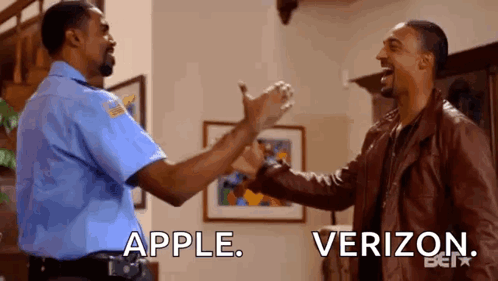 A Police Officer And A Man In A Leather Jacket Are Giving Each Other A High Five In A Living Room . GIF