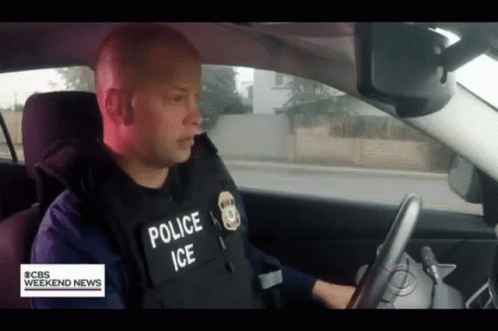 A Police Officer Is Driving A Car With Cbs Weekend News Written On The Bottom GIF