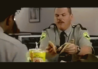 A Police Officer Is Eating A Hamburger In A Restaurant GIF