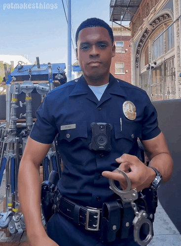 A Police Officer Is Holding A Pair Of Handcuffs In Front Of A Building With Patmakesthings Written Below Him GIF