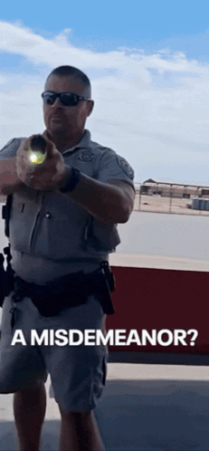 A Police Officer Is Pointing A Flashlight At The Camera With The Caption " A Misdemeanor " GIF