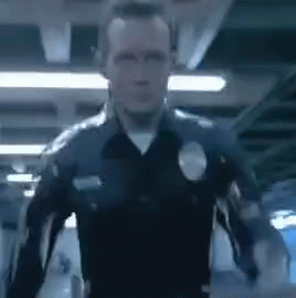 A Police Officer Is Standing In A Dark Room With His Arms Outstretched In A Blurry Photo . GIF