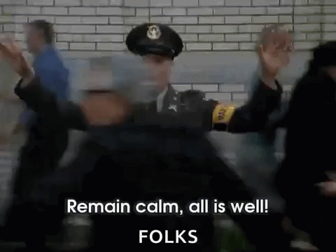 a police officer is standing in front of a crowd and says remain calm all is well folks