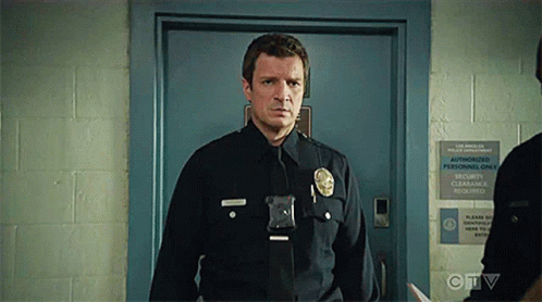 A Police Officer Is Standing In Front Of A Door With A Sign That Says Authorized Personnel Only . GIF