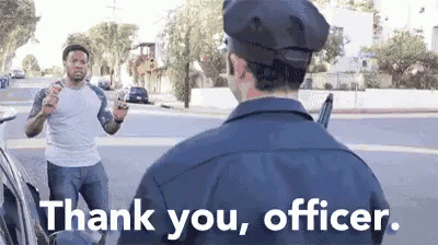 A Police Officer Is Talking To A Man Who Is Holding A Gun In His Hand . GIF