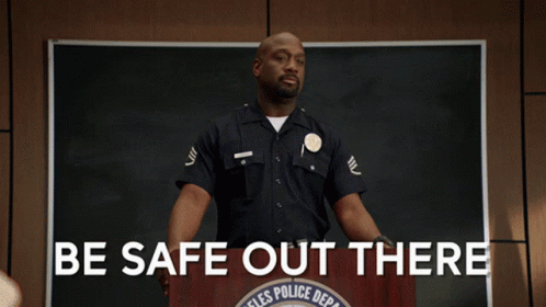 A Police Officer Stands At A Podium With The Words Be Safe Out There GIF