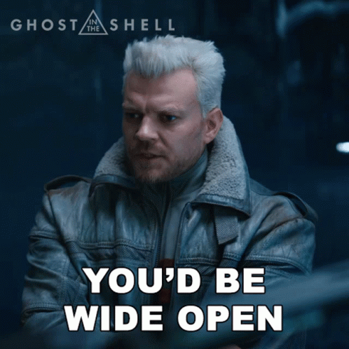 A Poster For Ghost In The Shell Shows A Man In A Leather Jacket With His Arms Crossed GIF