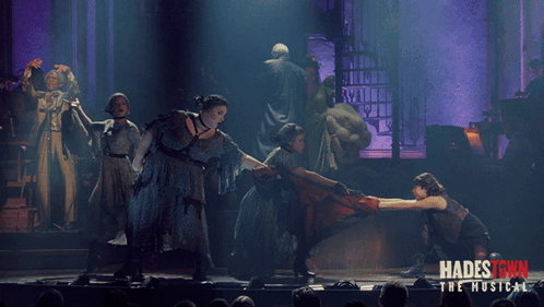 A Poster For Hadestown The Musical Shows A Group Of People Dancing On A Stage GIF