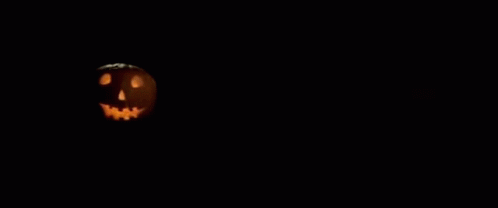 A Poster For John Carpenter 'S Halloween With A Pumpkin In The Background GIF