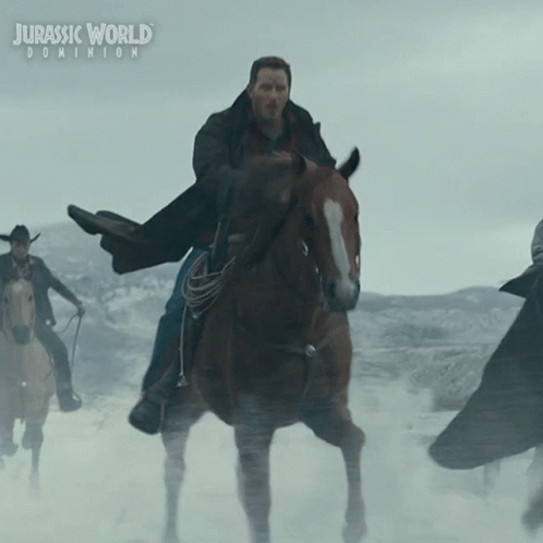 A Poster For Jurassic World Dominion Shows A Man Riding A Brown Horse GIF