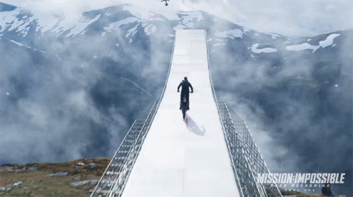 A Poster For Mission Impossible Shows A Man Riding A Motorcycle Over A Bridge GIF