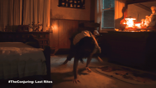 A Poster For The Conjuring Last Rites Shows A Woman Doing Push Ups GIF