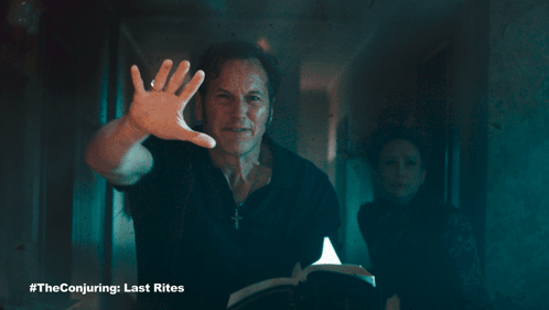 A Poster For The Conjuring Last Rites With A Man Holding A Book GIF