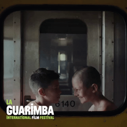 A Poster For The Guarimba International Film Festival With Two Boys Looking At Each Other GIF