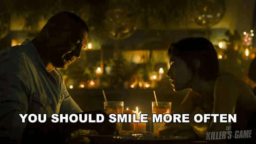 A Poster For The Killer 'S Game Shows A Man And A Woman At A Table GIF
