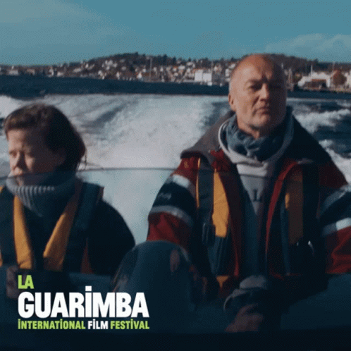A Poster For The La Guarimba International Film Festival Shows A Man And A Woman In A Boat GIF