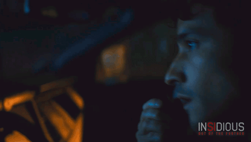 A Poster For The Movie Insidious Shows A Man Talking On A Phone GIF
