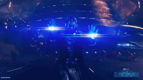 A Poster For The Movie Quantumania Shows A Person Holding A Beam Of Light GIF